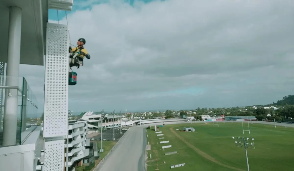 Alpine-Tech 360 rope access technician servicing shutter screens on a commercial building in Auckland